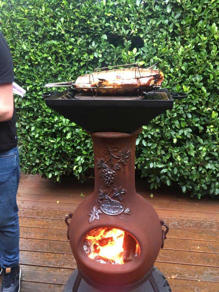 Cooking a fish on a chiminea